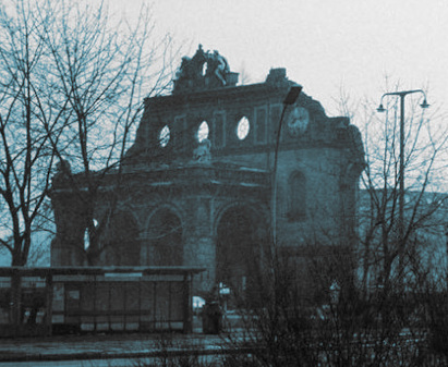 ruined 
facade with three round windows over a portico