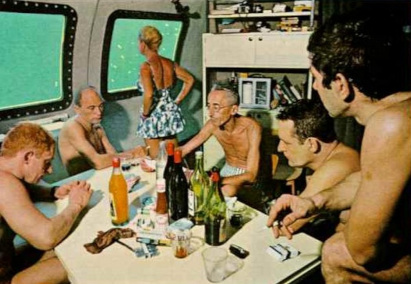 Jacques Cousteau at table with crew drinking wine 
and smoking as his wife Simone gazes out the window, 
10 meters beneath the Red Sea