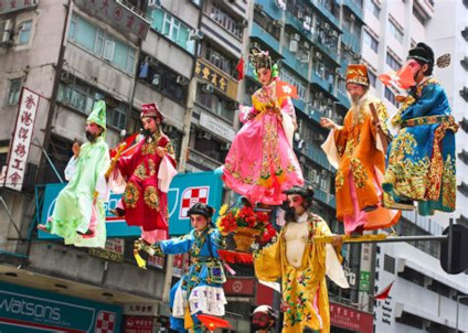 Children in gaudy dress mounted on a frame, paraded through 
Honk Kong streets during the Cheung Chau Bun Festival